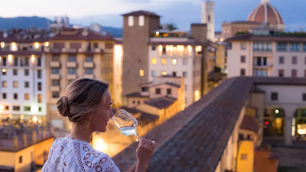 Woman In Beautiful White Dress Enjoying A Glass Of Wine With The View Of Florence 1349106162
