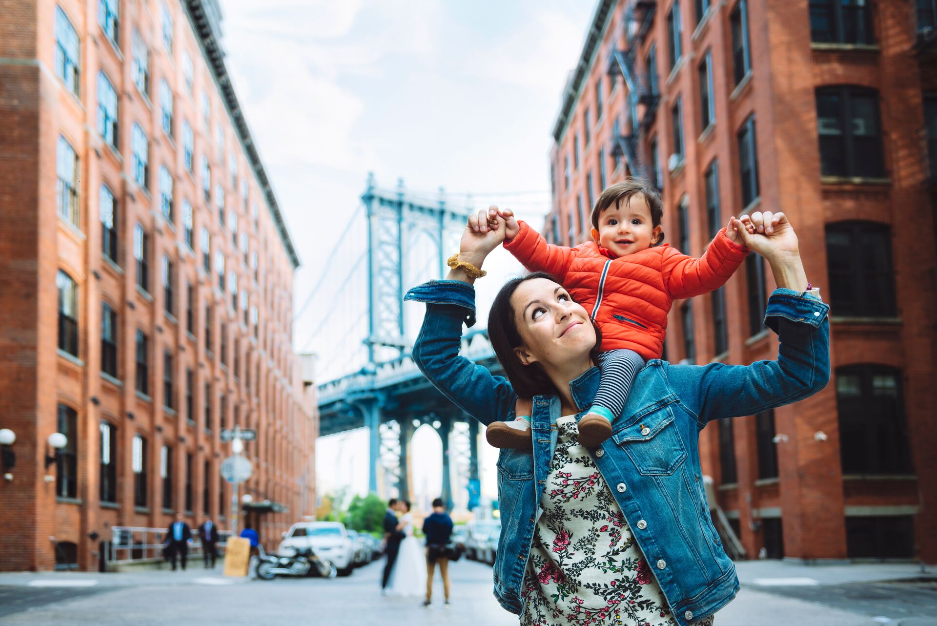 Mother and baby in Brooklyn with Manhattan Bridge in the background 