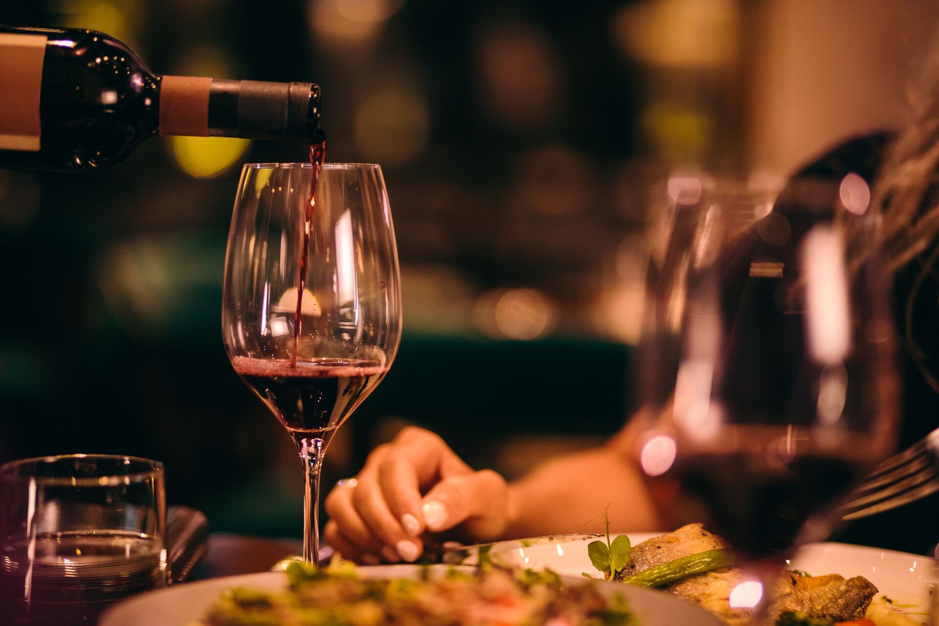 Large Close Up Of Sommelier Serving Red Wine At Fine Dining Restaurant