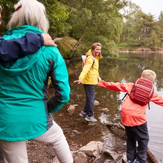 Two children playing in a lake with their grandparents in the foreground