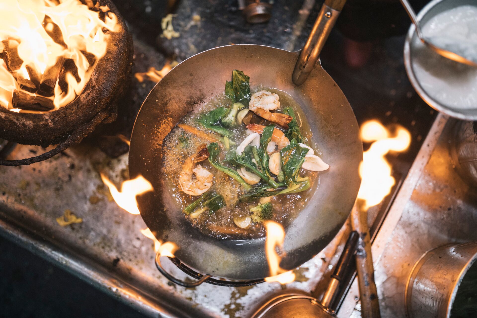Aerial view of a stir fry in a wok over a charcoal grill 