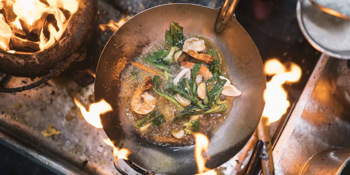 Aerial view of a stir fry in a wok over a charcoal grill