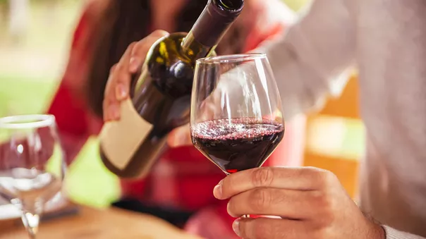 Traveller pouring red wine into glass