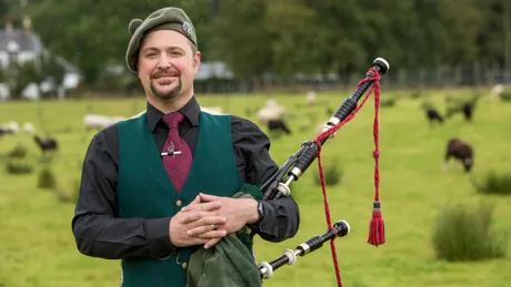 Gregor Wood from Ledard Farm wearing traditional Scottish clothes and holding pipes in Scotland