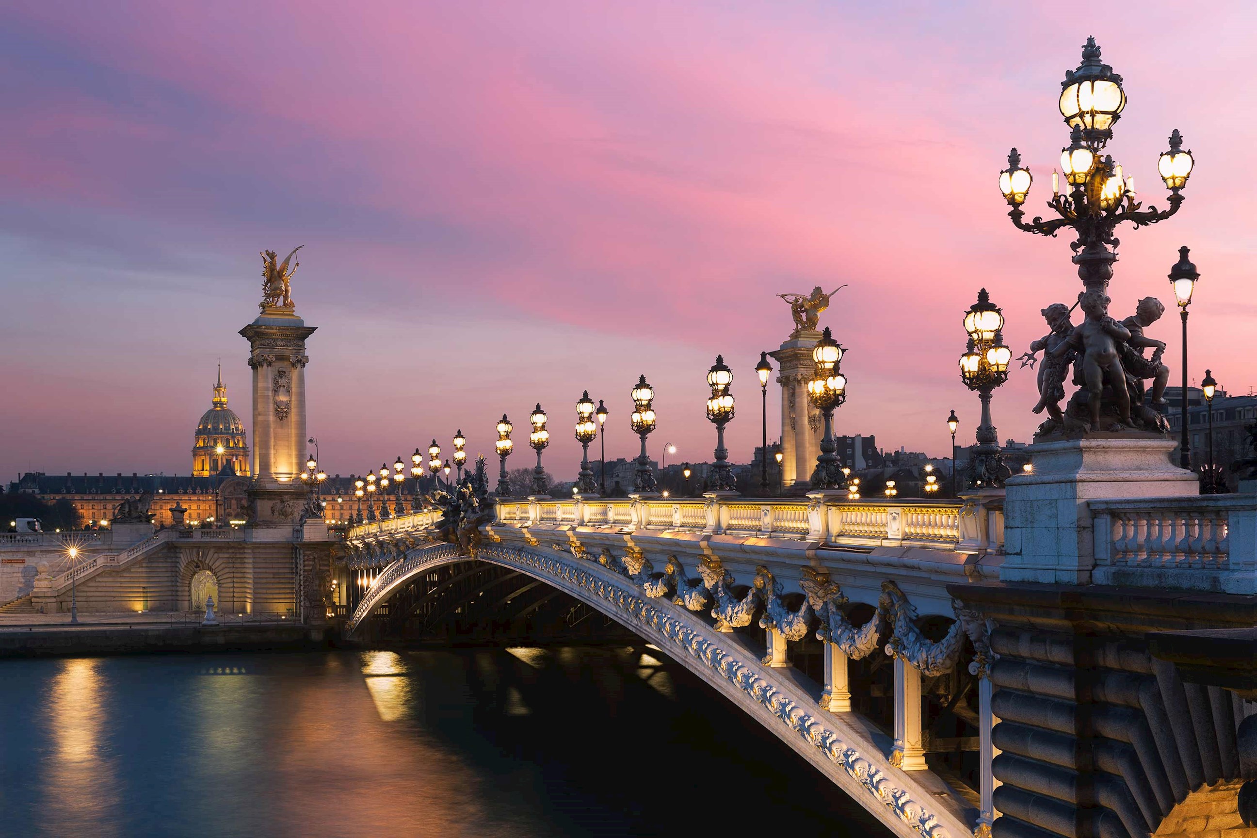 An evening view of the Pont Alexandre III Bridge in Paris, France