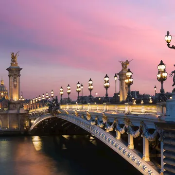 An evening view of the Pont Alexandre III Bridge in Paris, France