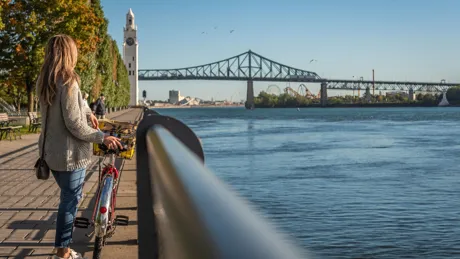 Woman biking in Montreal with the Jacques Cartier Bridge in the background