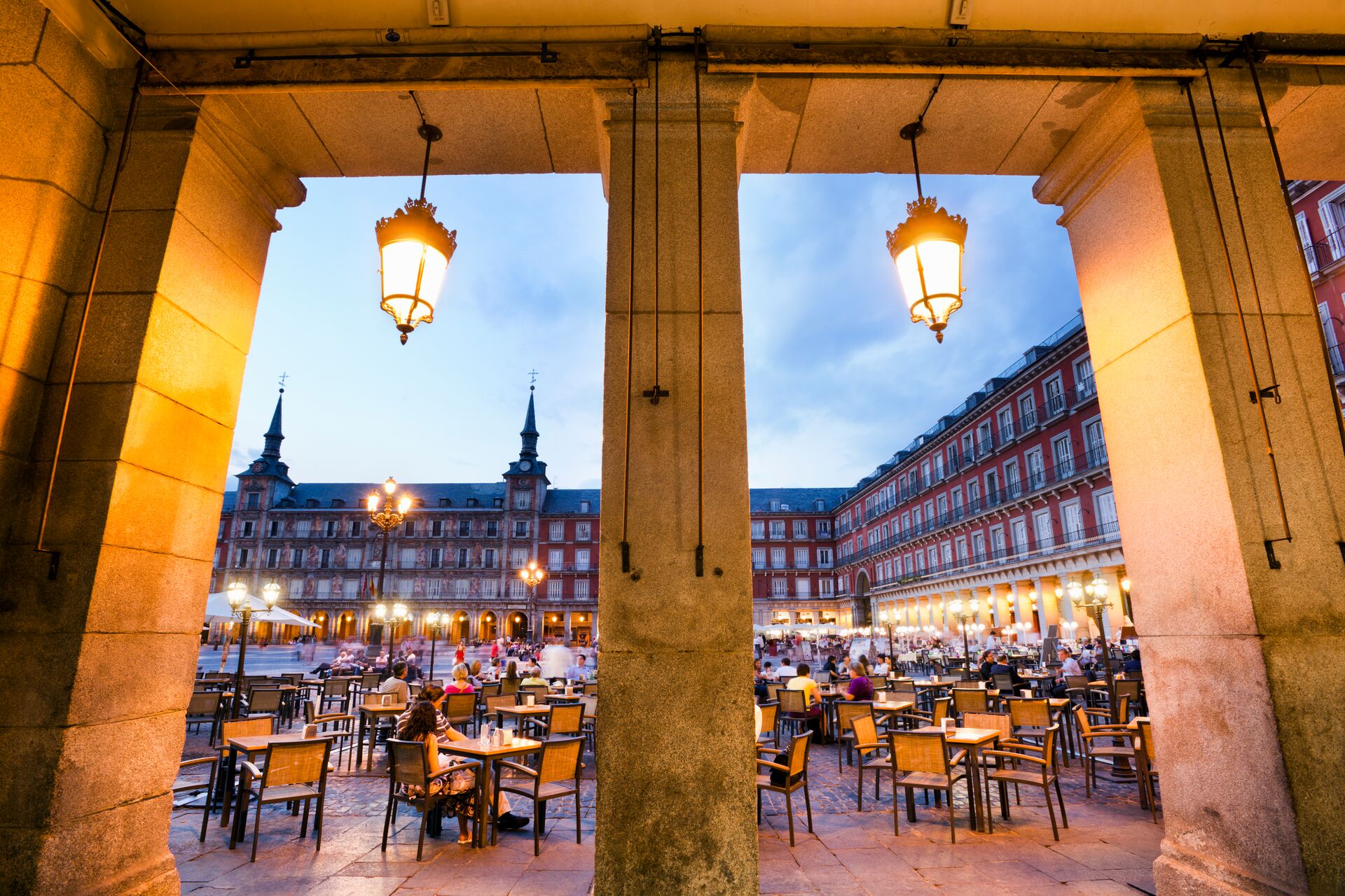 Dusk gently lights Plaza Mayor, with lots of chairs set out for diners