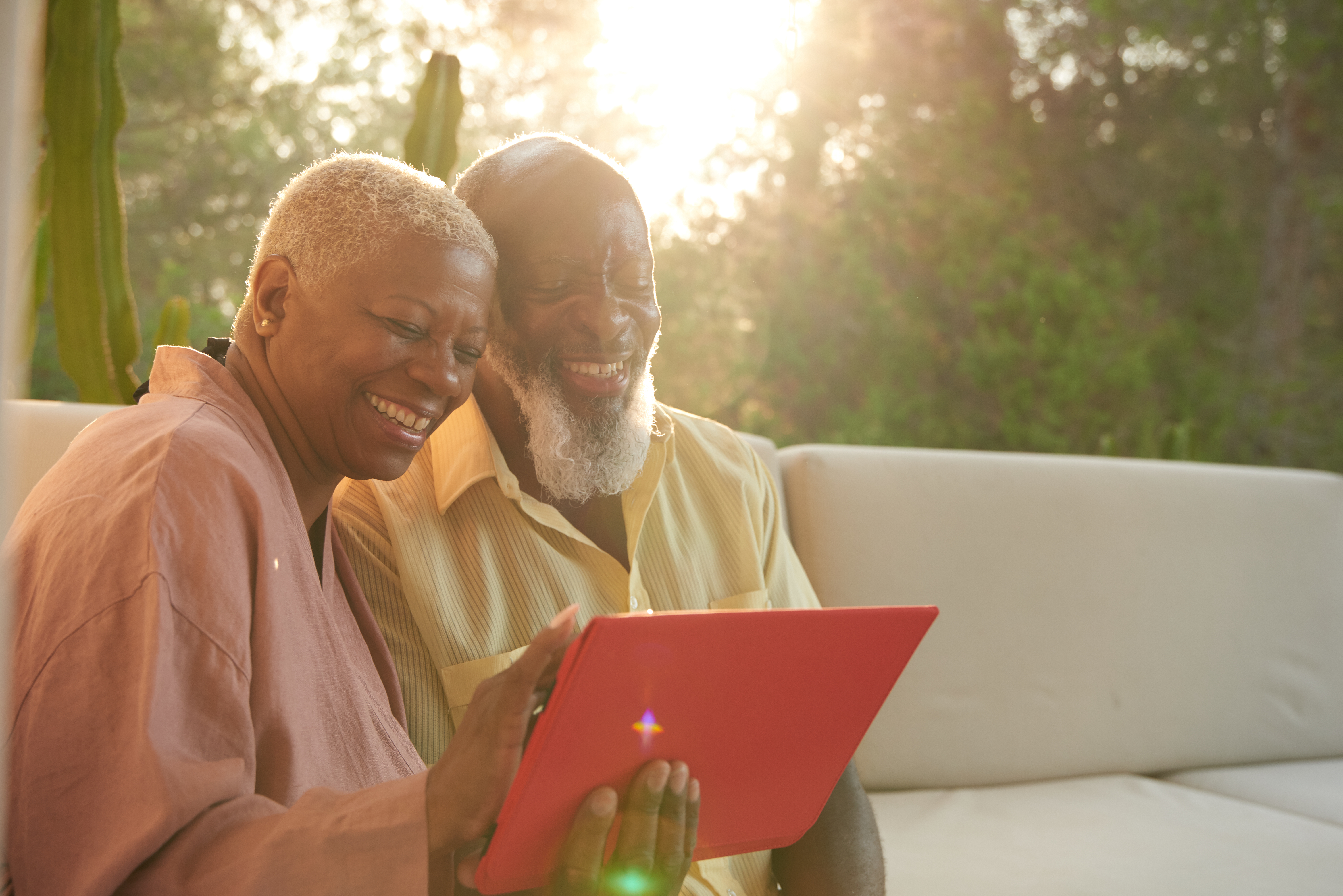 Older Couple Laugh With A Digital Tablet 1192109754