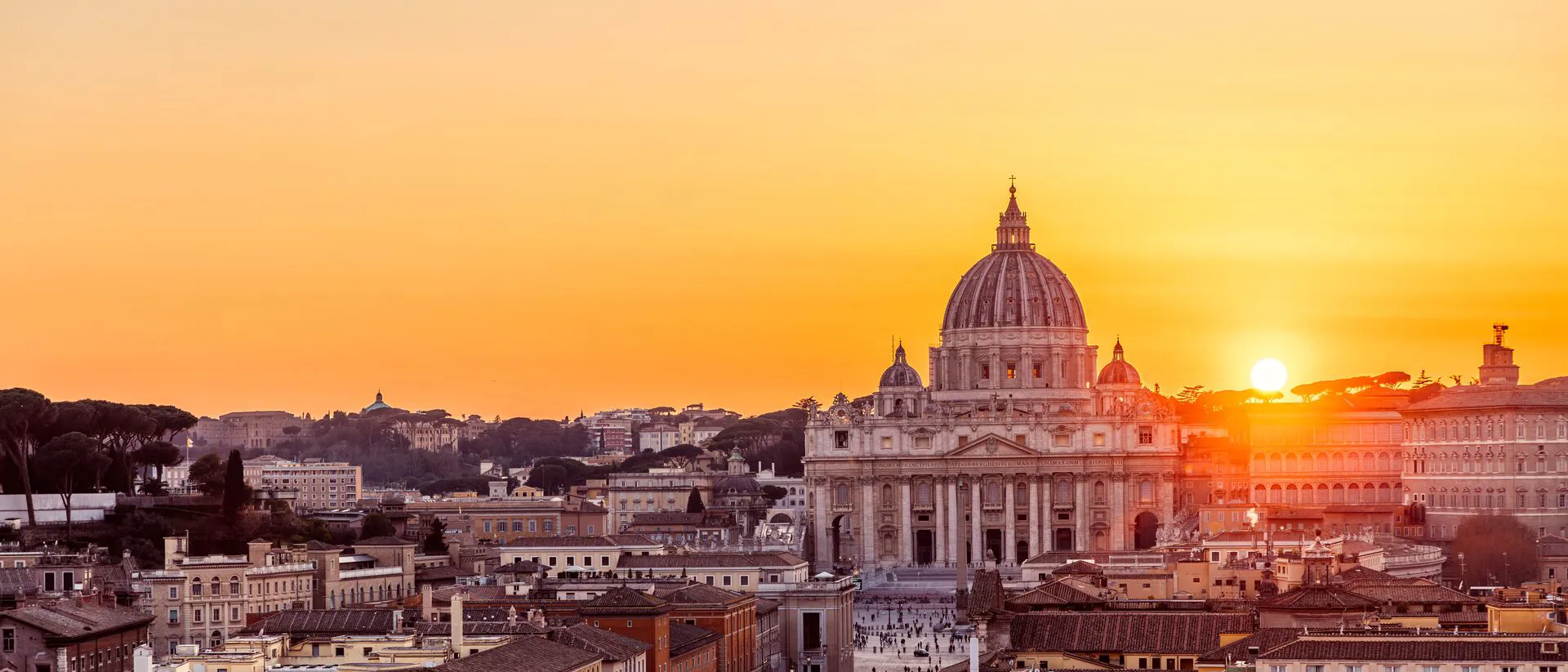 The sun is setting over St. Peter's Basilica, Rome
