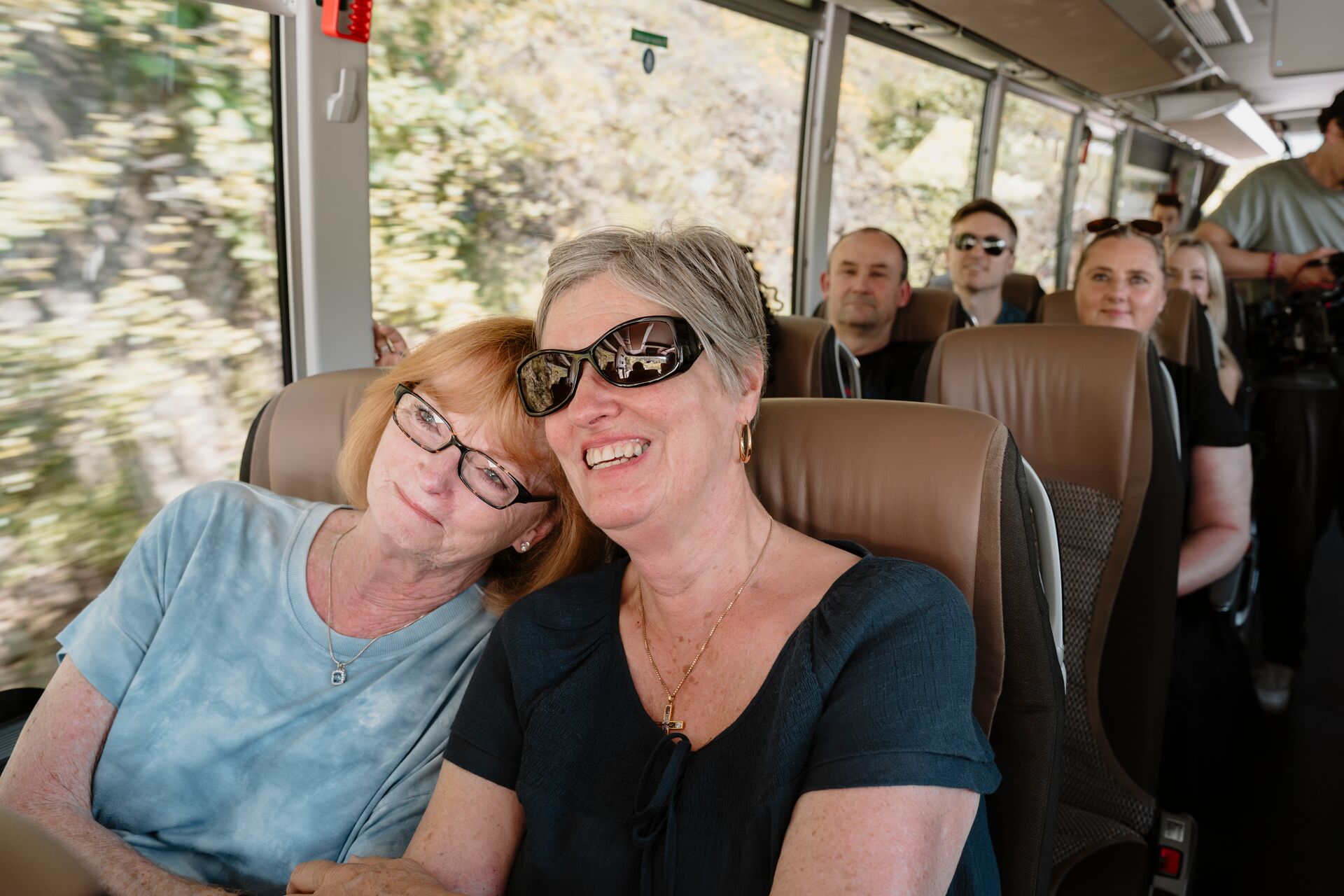 Two women smiling sitting on a coach