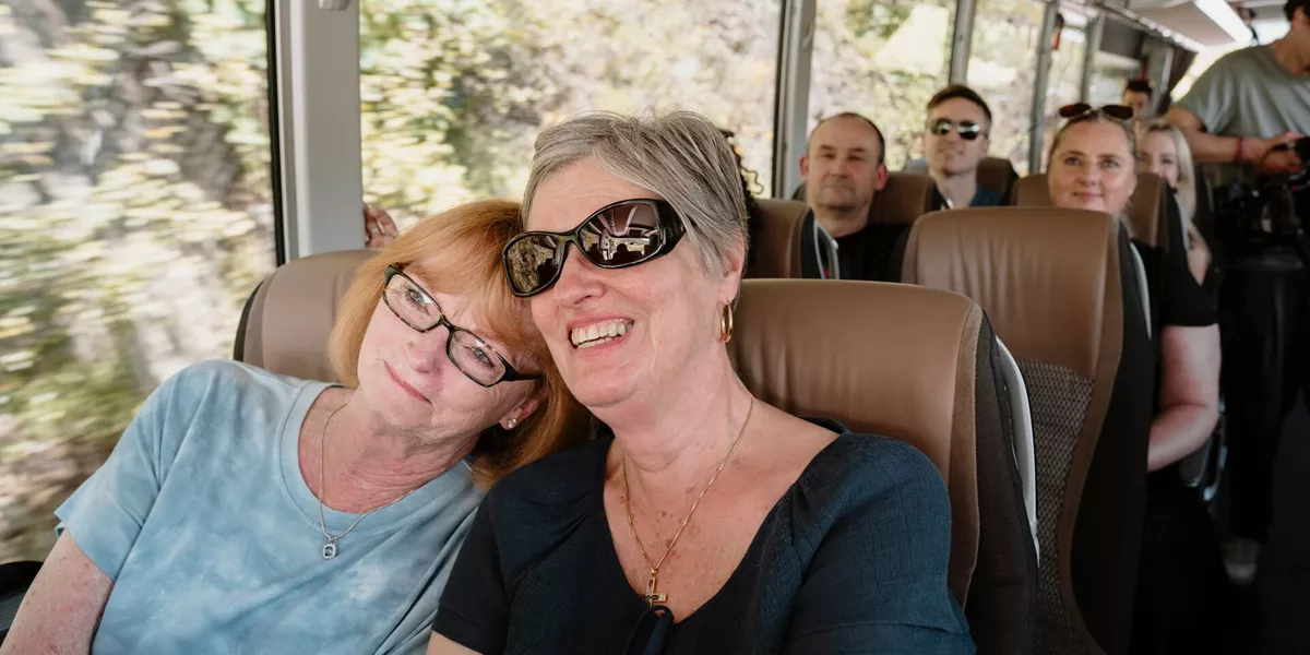 Two women smiling sitting on a coach