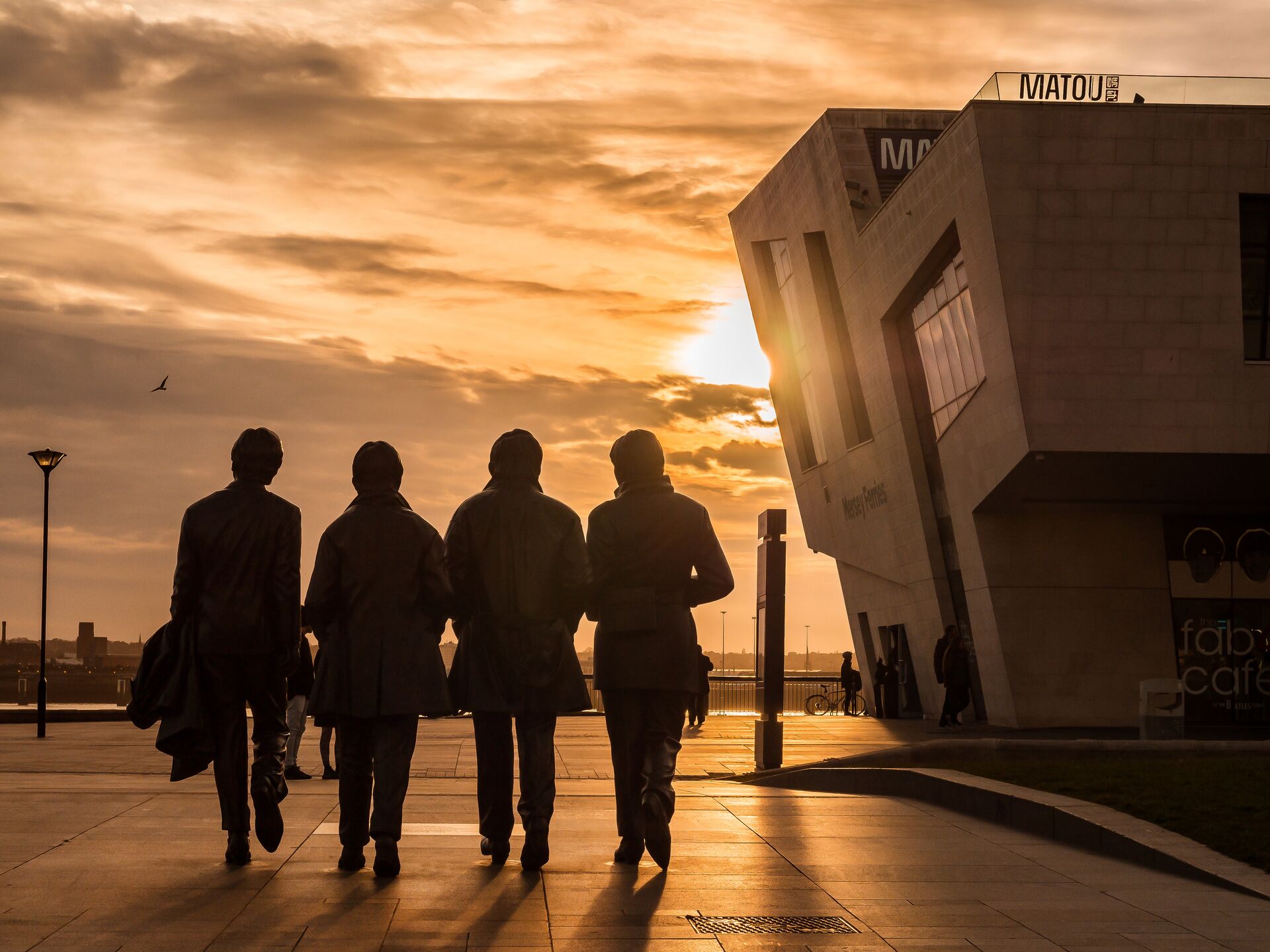 Sun setting over the Beatles statues in the centre of Liverpool, England