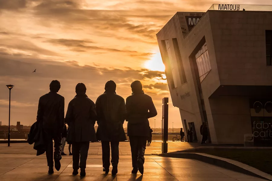 Sun setting over the Beatles statues in the centre of Liverpool, England