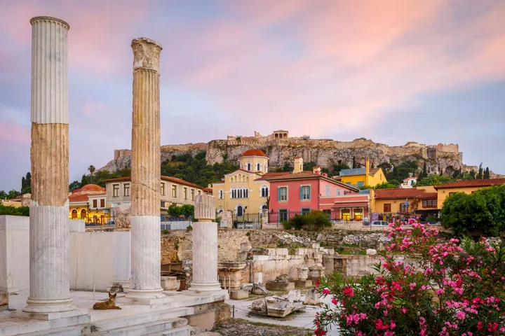 Pillars of Acropolis in foreground with colourful houses behind