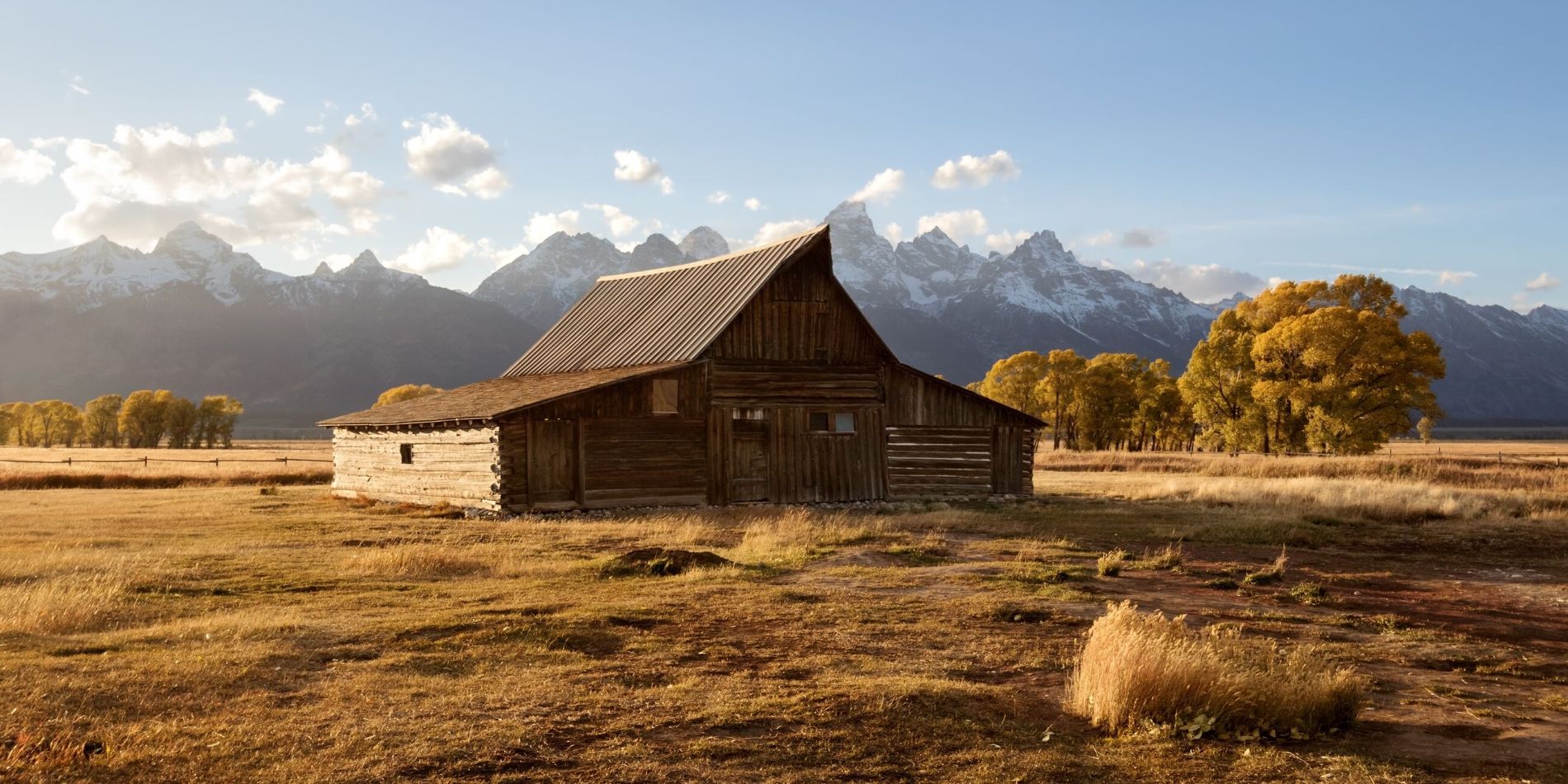 A barn in a field with mountains in the background in Grand Teton National Park, Wyoming