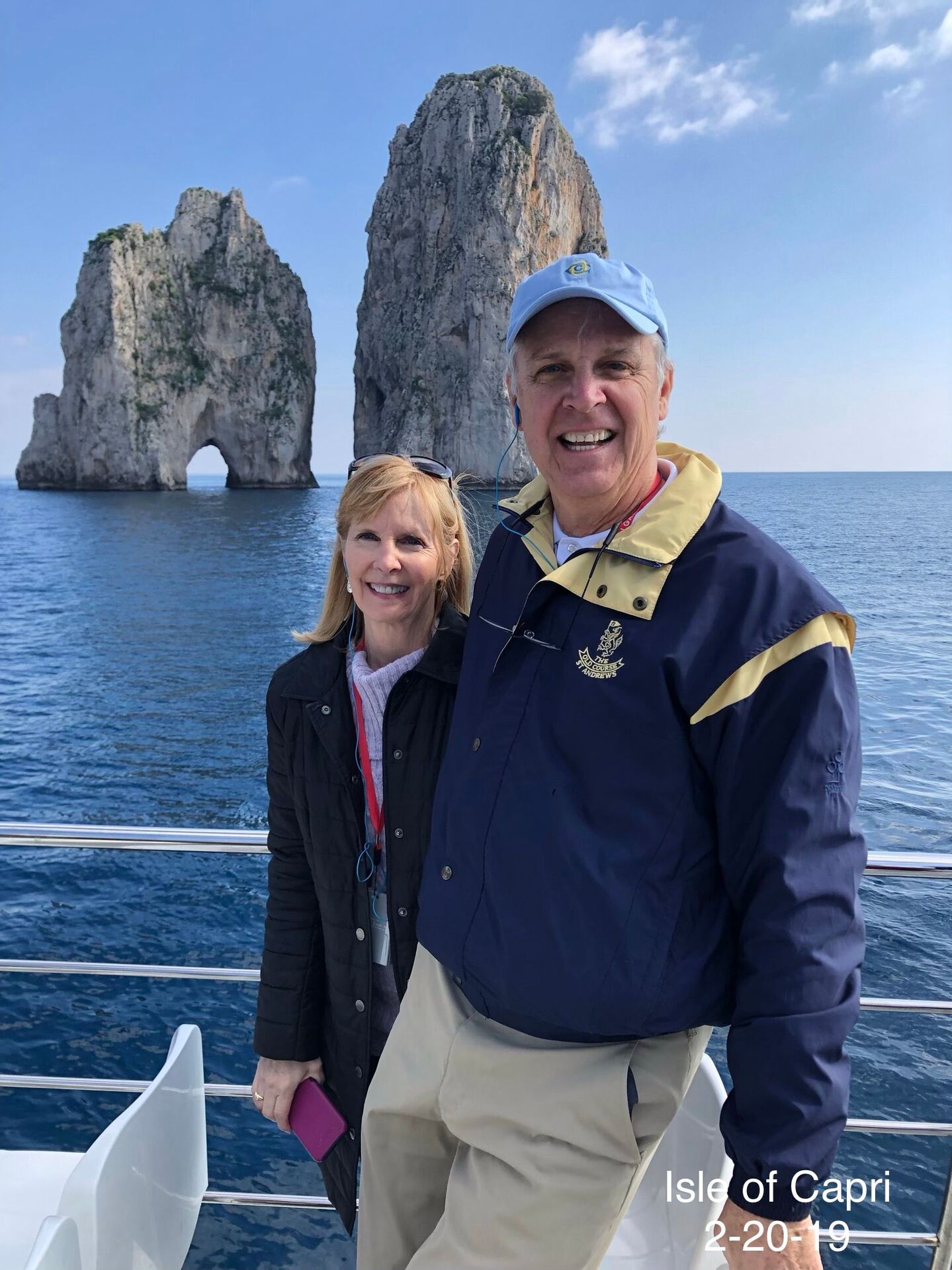 Roxanne Foster standing on a boat with Tour Director nearby rocks close to Isle of Capr