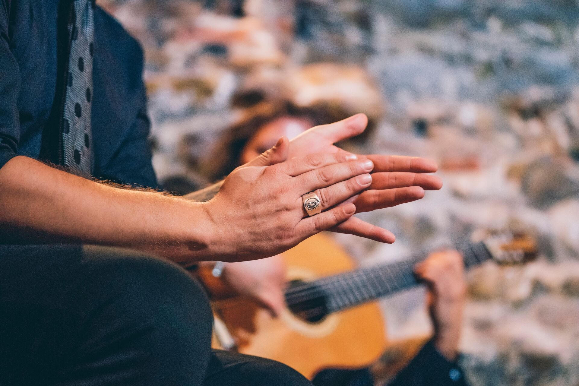 close-up-of-singer-clapping-hands-while-man-playing-guitar-in-club-1255078234.jpeg