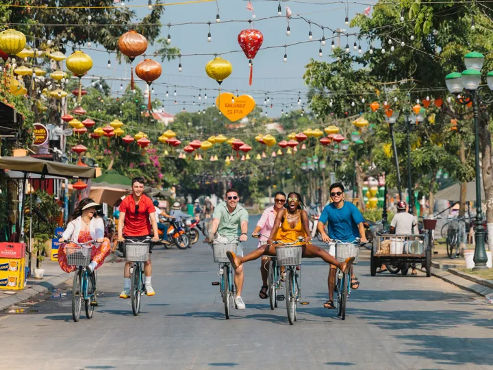 A group of people riding bikes down a street in Vietnam