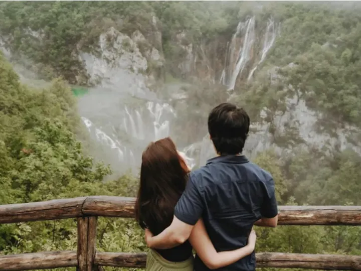 Couple watching the waterfalls from the wooden bridge