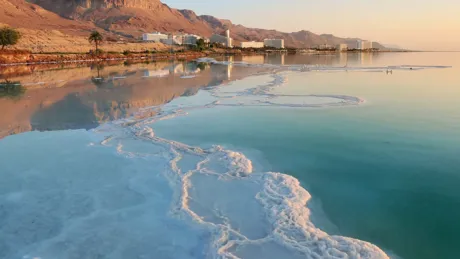 The Dead Sea with buildings and a mountain in the background
