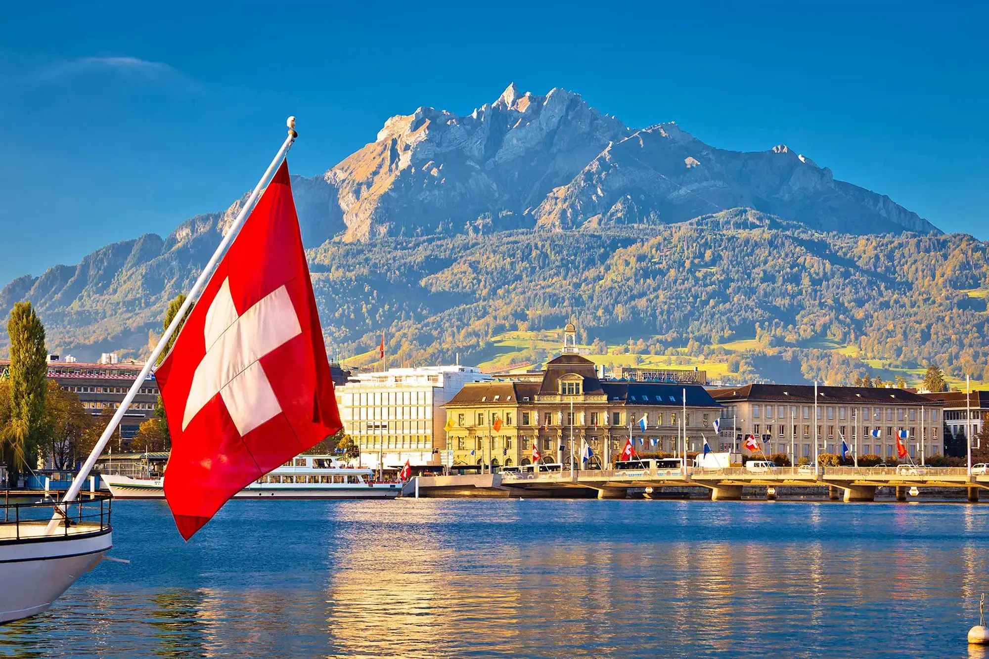 A Swiss flag waving over Pilatus Lake in Lucerne, Switzerland