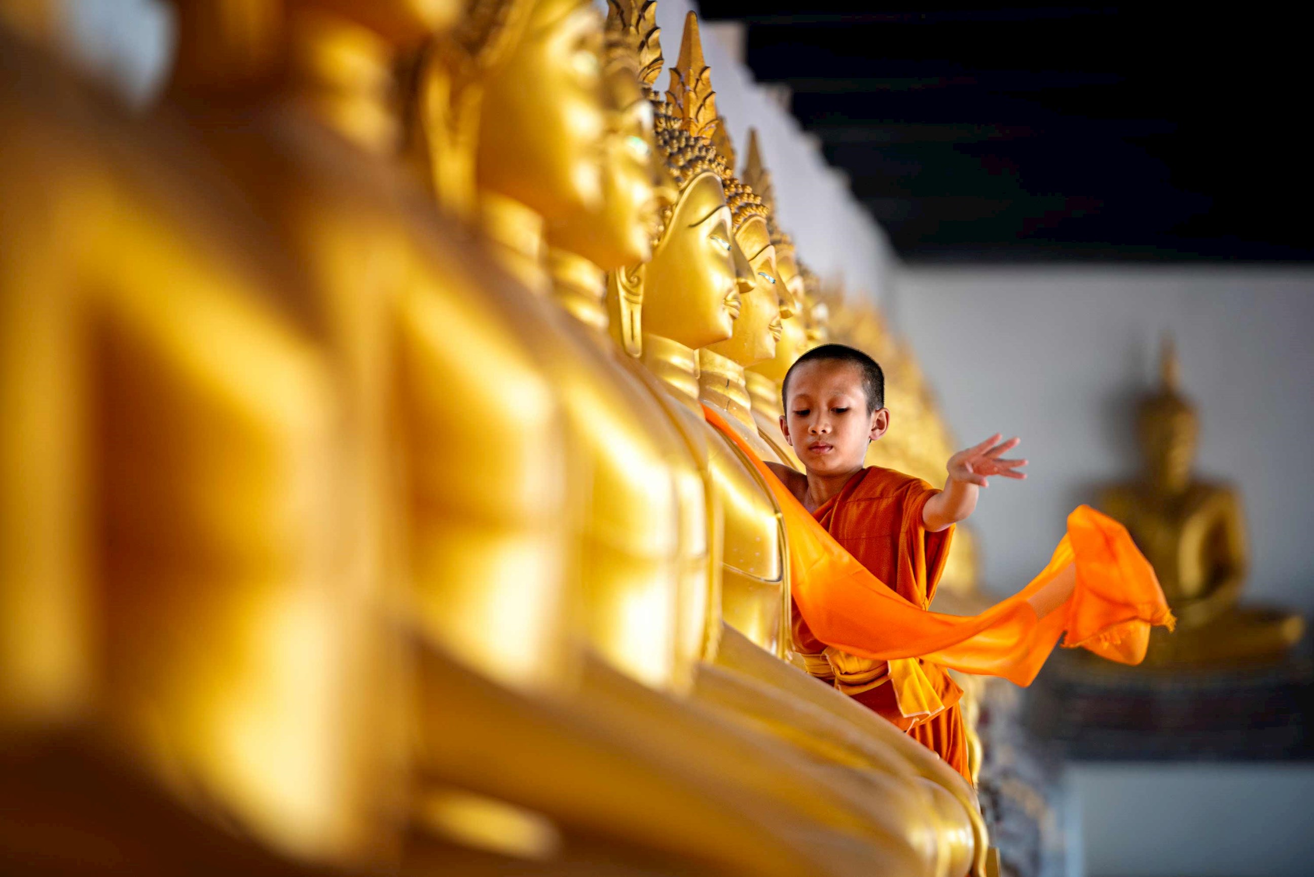 boy-covering-cloth-buddha-statue-siem-reap-cambodia.jpg