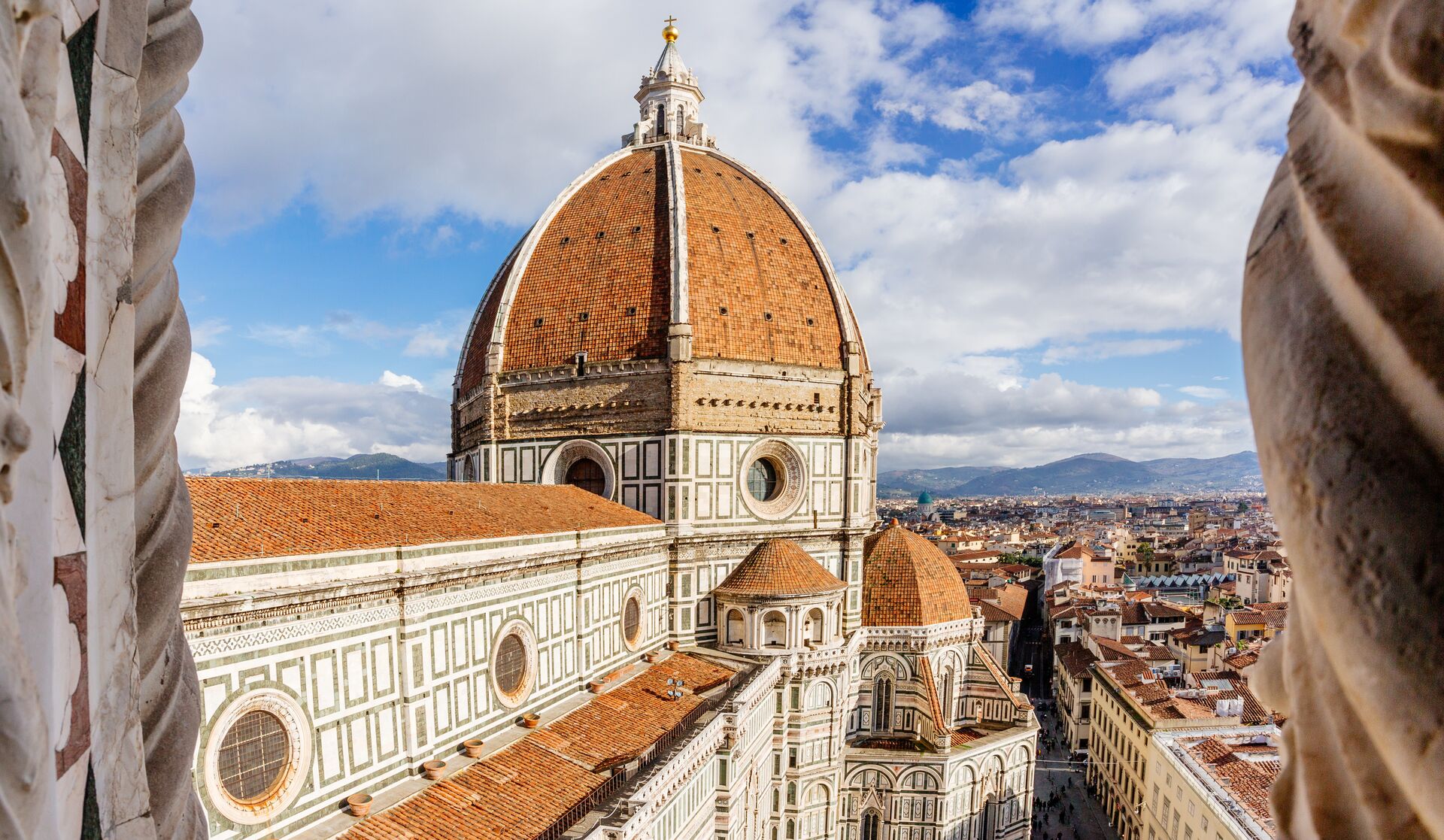Aerial view of Brunelleschi Dome in Florence, Italy with a few clouds in the background