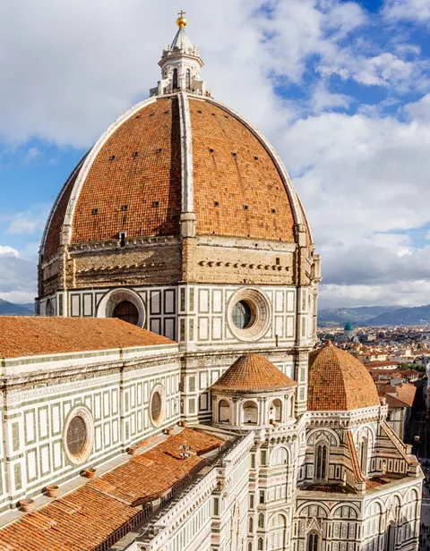 Aerial view of Brunelleschi Dome in Florence, Italy with a few clouds in the background