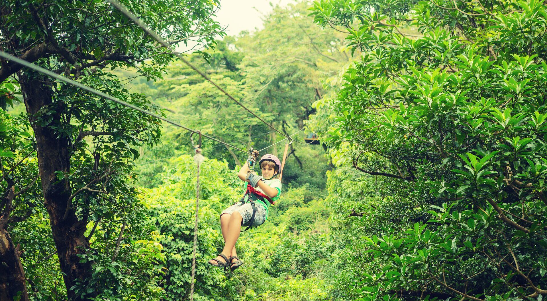 Kid on a zipline through the the canopy in Costa Rica