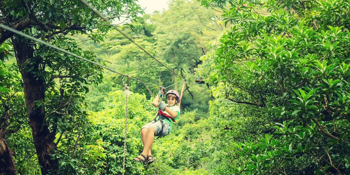 Kid on a zipline through the the canopy in Costa Rica