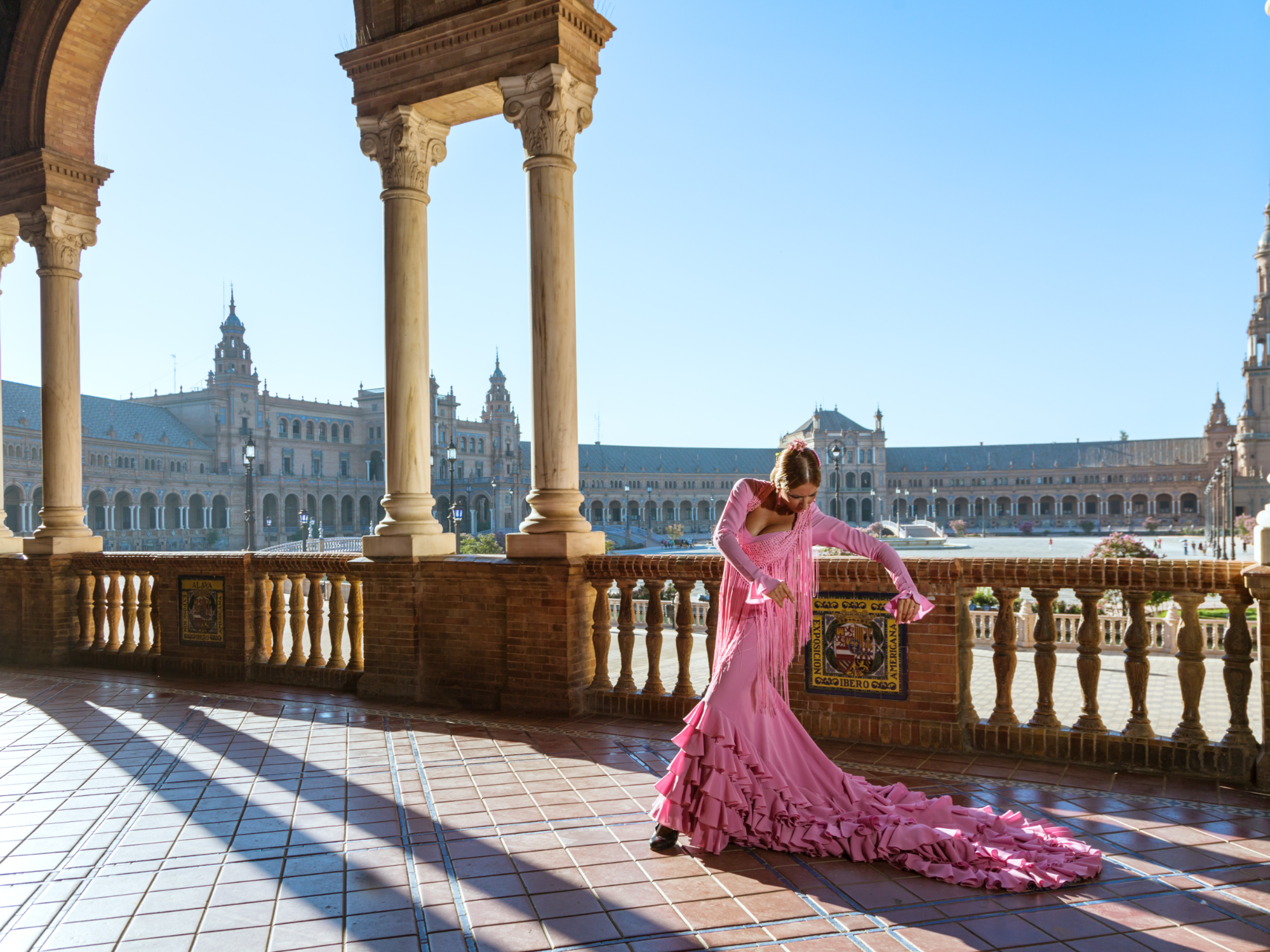Woman in pink dress dancing on terrace in Seville, Spain