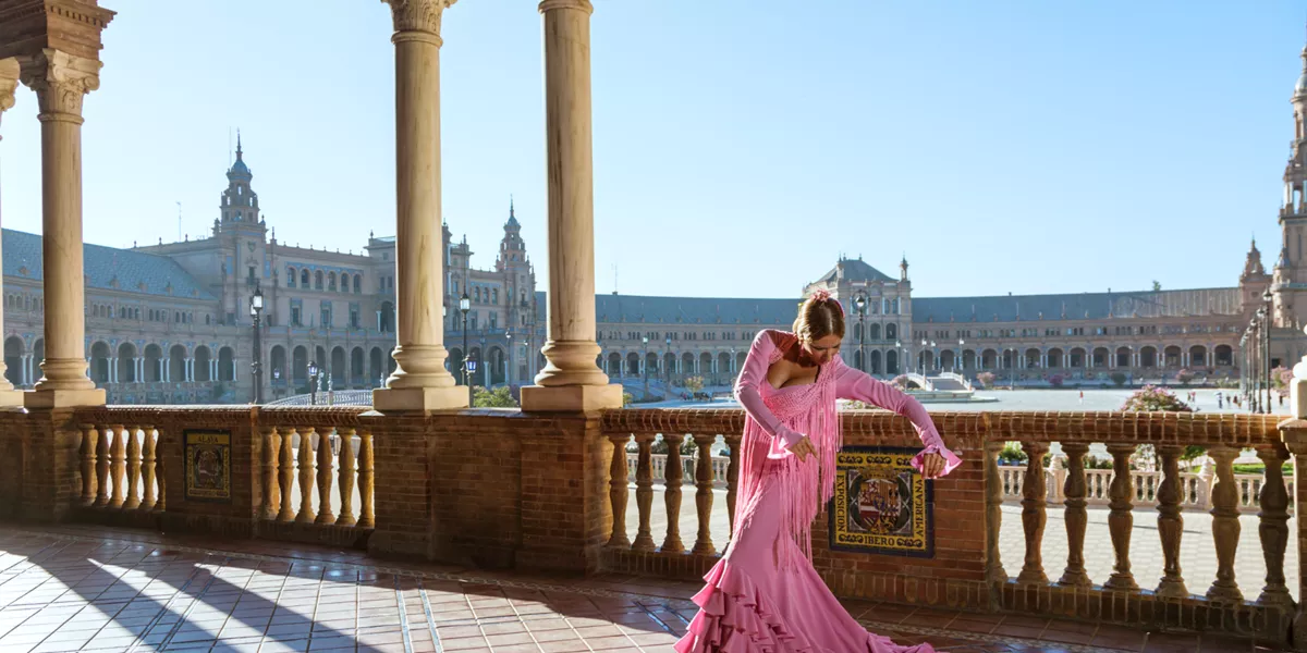 Woman in pink dress dancing on terrace in Seville, Spain