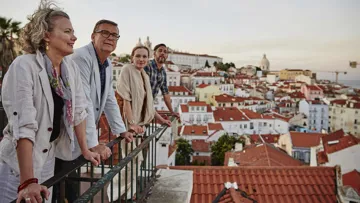 Travellers looking over a balcony in Lisbon, Portugal