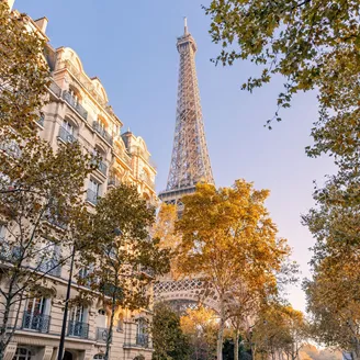 The Eiffel Tower with traditional town houses in the foreground during autumn in Paris, France