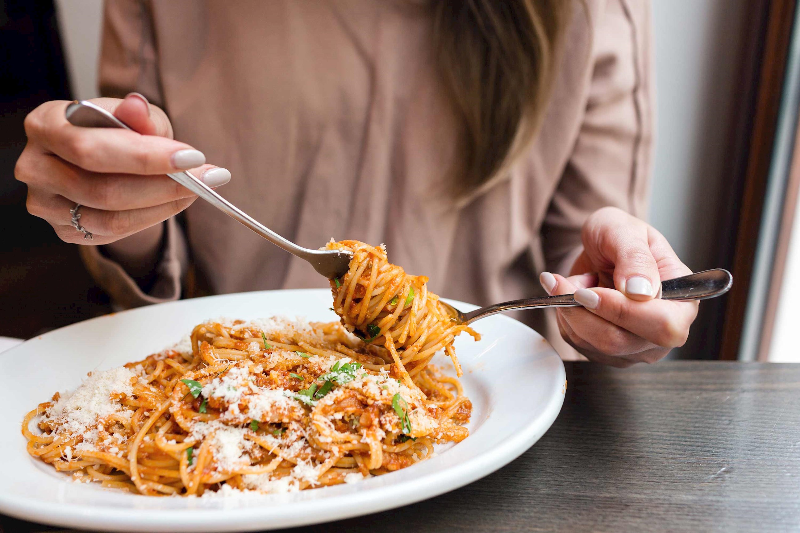Woman eating Spaghetti Bolognese in Bologna, Italy