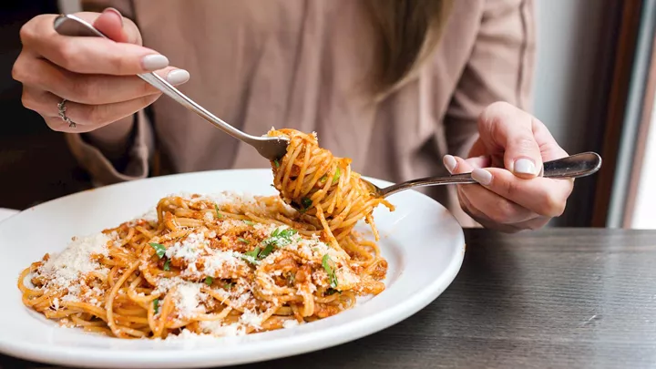 Woman eating Spaghetti Bolognese in Bologna, Italy