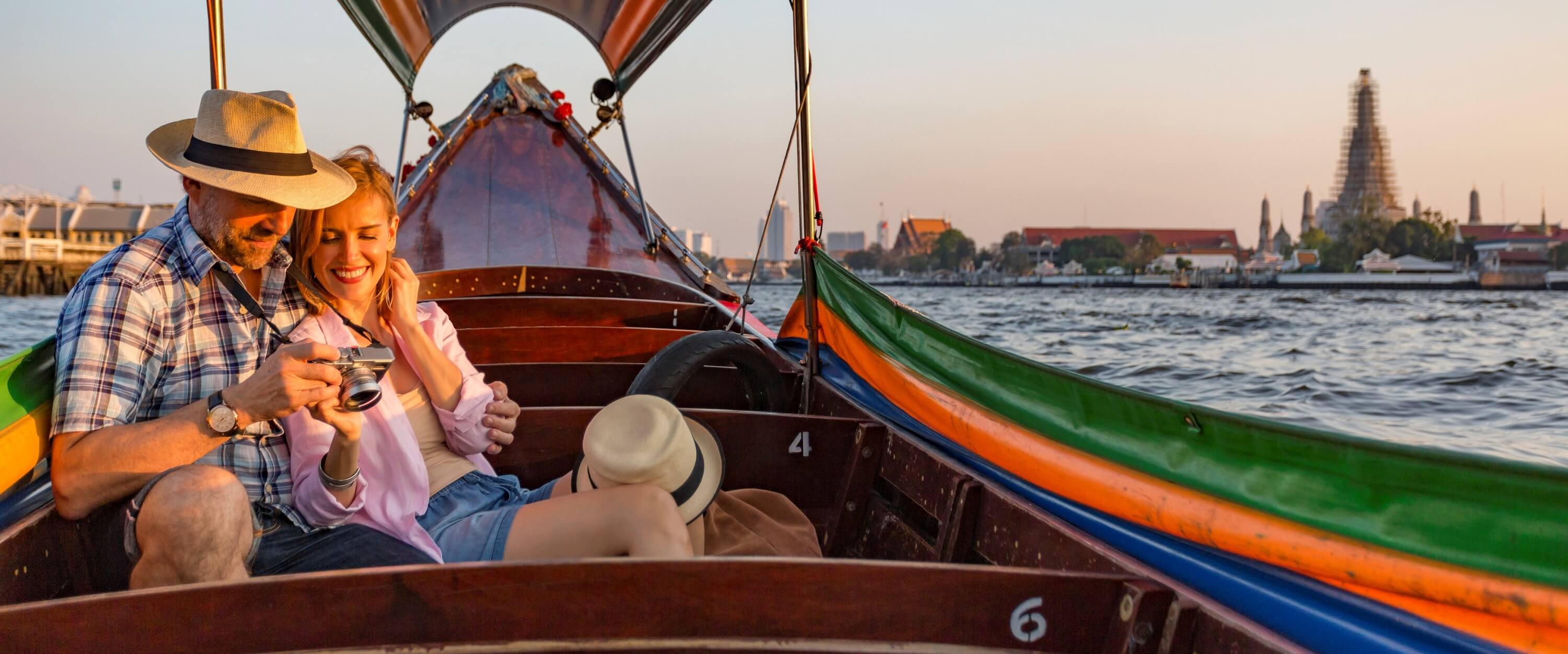 A man and a woman sitting in a boat on the water CopyDownload