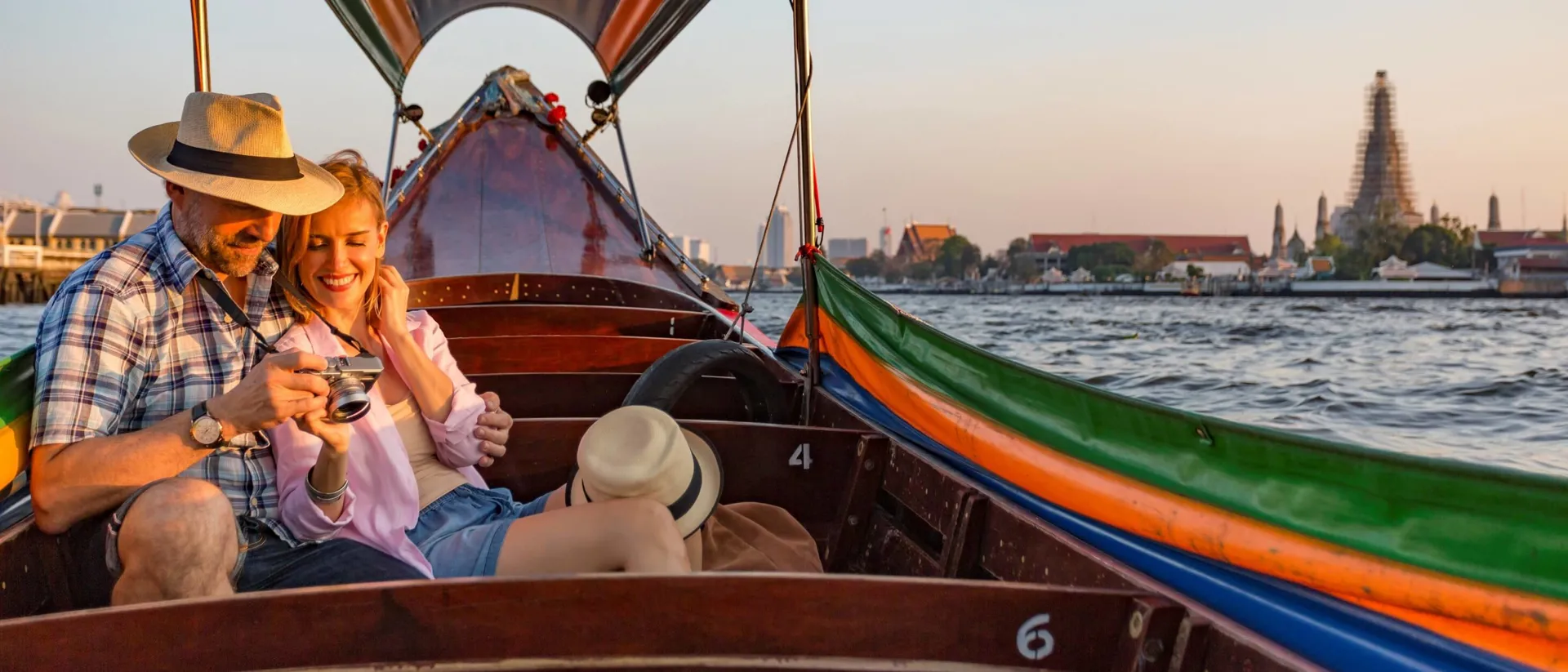 A man and a woman sitting in a boat on the water CopyDownload