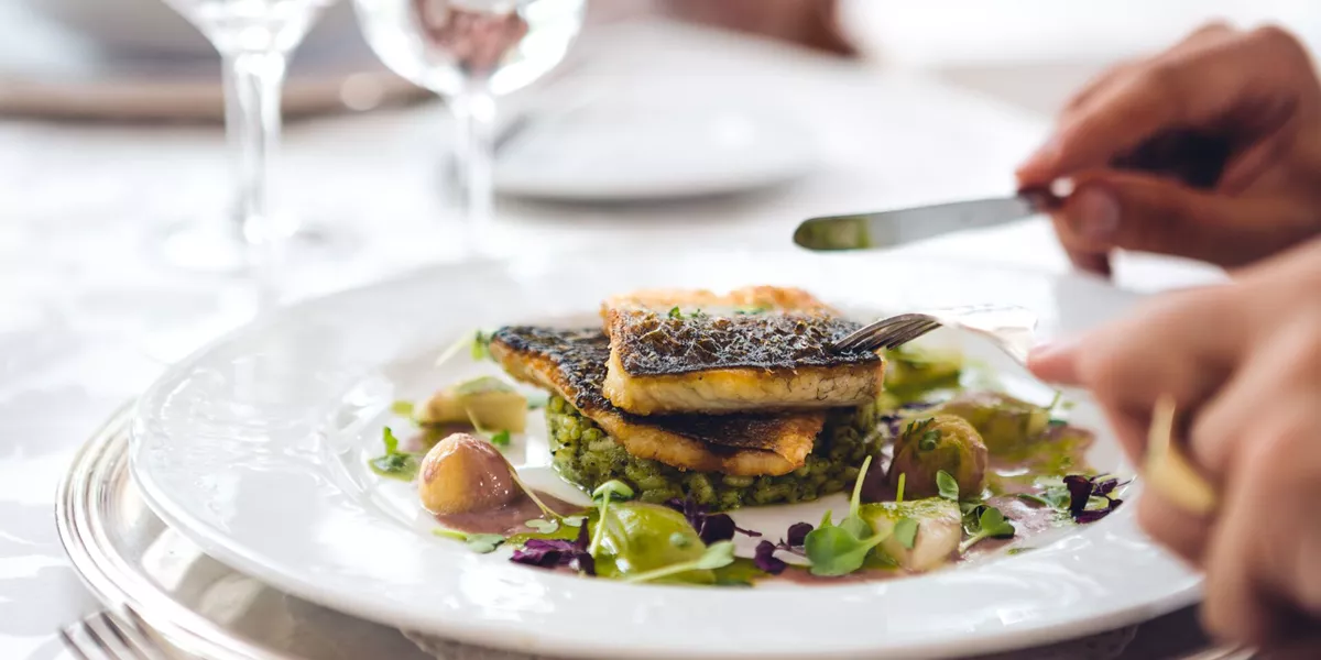 Large Man In Restaurant Eating Fish 516691894