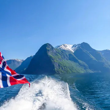 A Norwegian flag sailing over Sognefjord