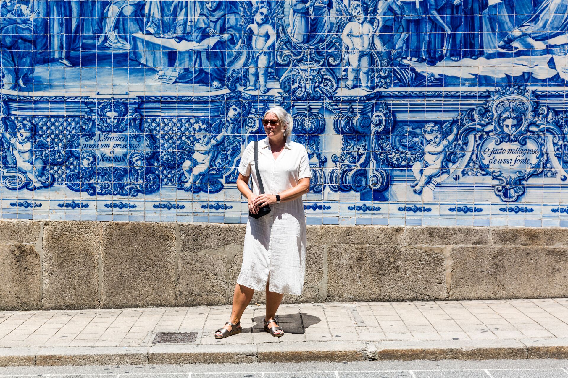 Woman standing infront of Porto's iconic white and blue tiling