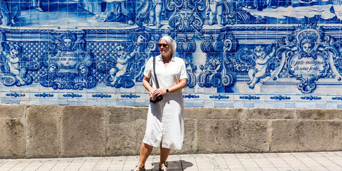 Woman standing infront of Porto's iconic white and blue tiling