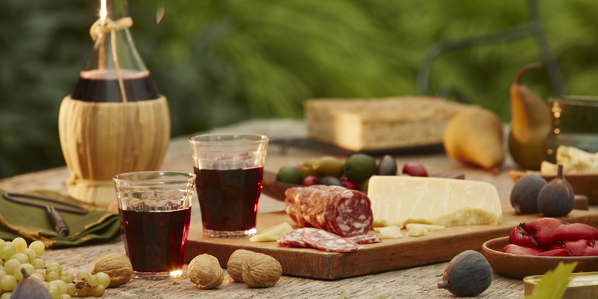 Wine, local cheeses and meats spread on a wooden table in Italy