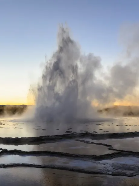 A geyser spewing water into the air at sunset in USA, Wyoming, Yellowstone National Park