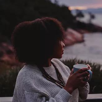 Lady drinking coffee at sunrise