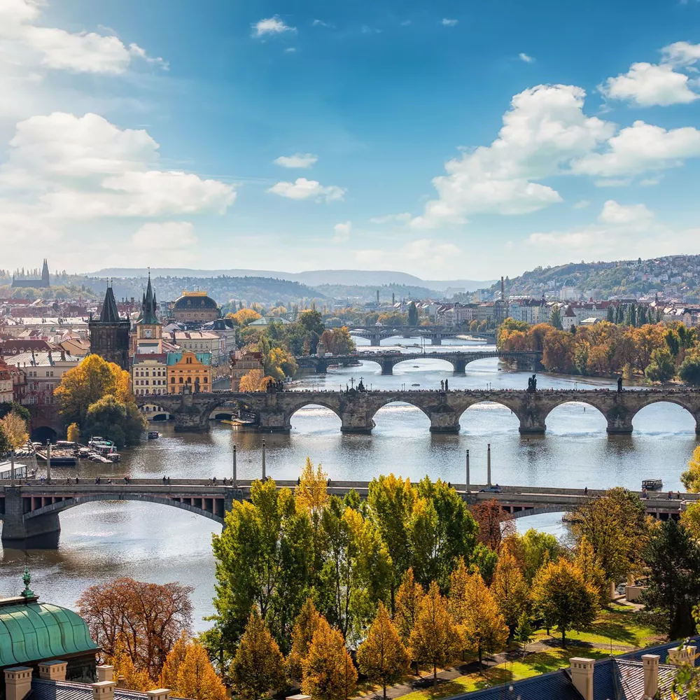 Arch Bridge Over River Amidst Buildings Against Sky