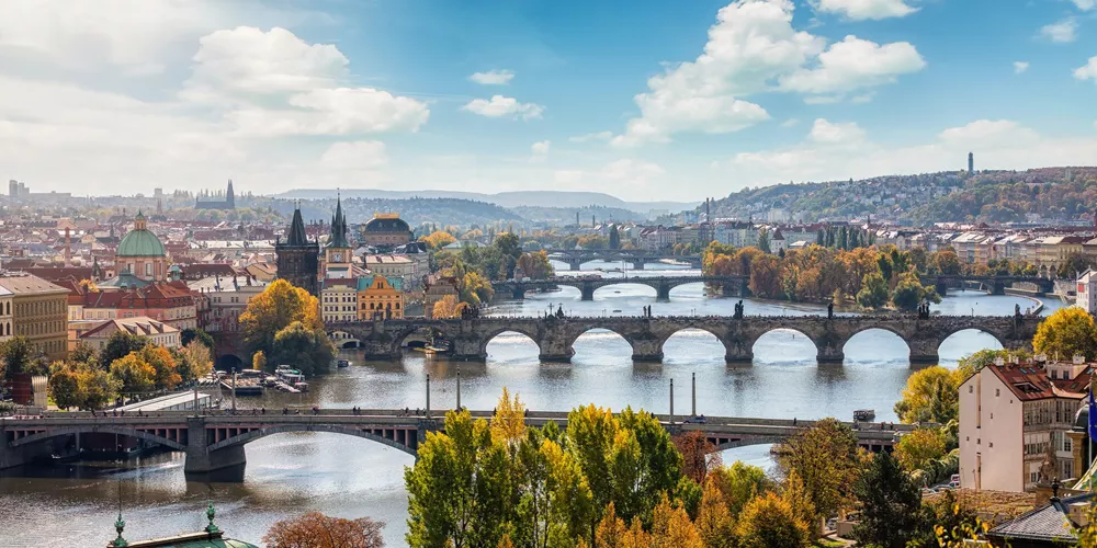 Arch Bridge Over River Amidst Buildings Against Sky
