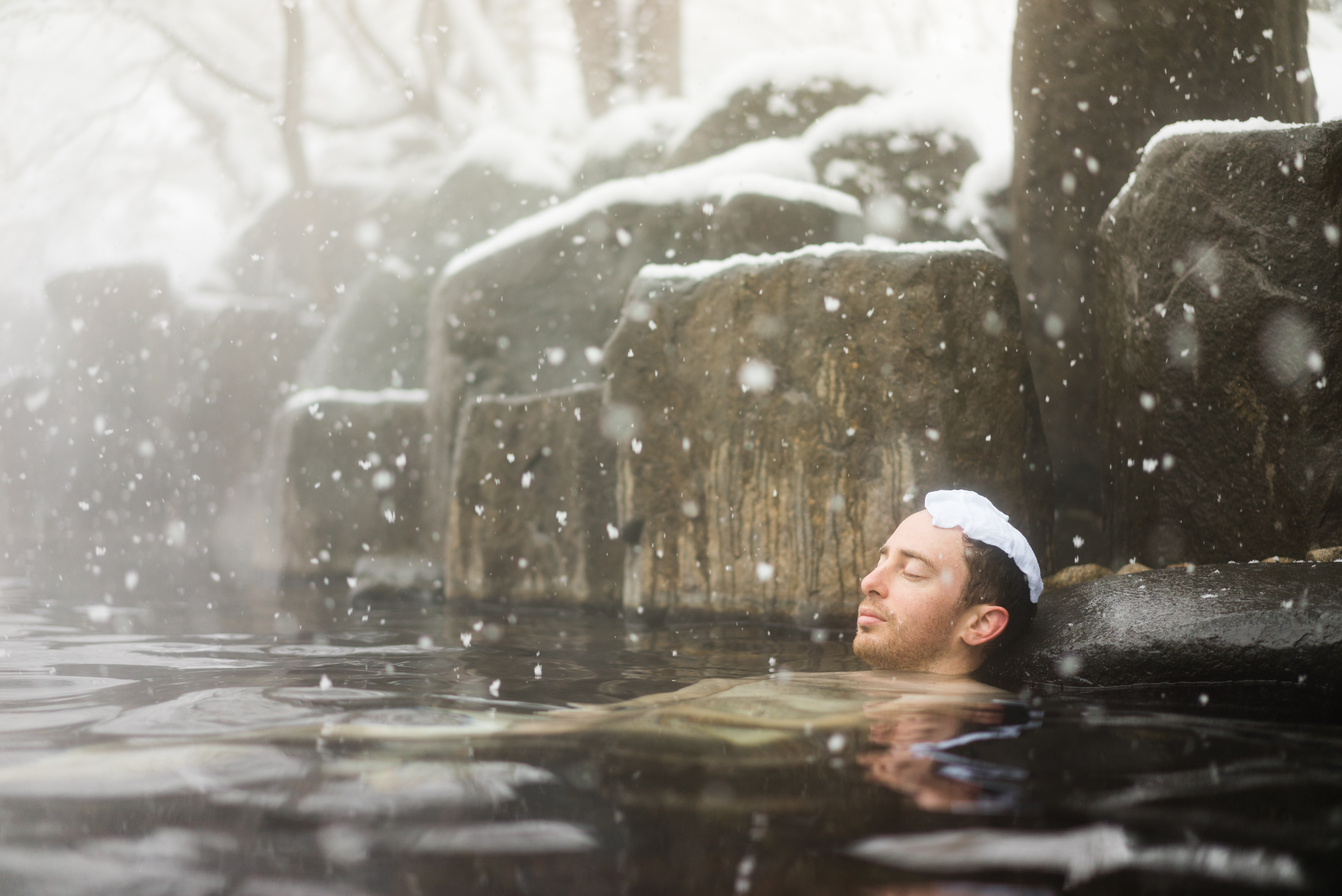 Western Tourist Enjoying Natural Hot Spring Onsen During Winter Snow 624685300
