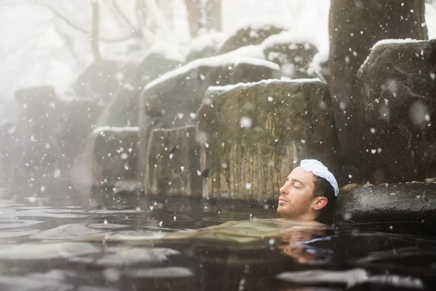 Western Tourist Enjoying Natural Hot Spring Onsen During Winter Snow 624685300